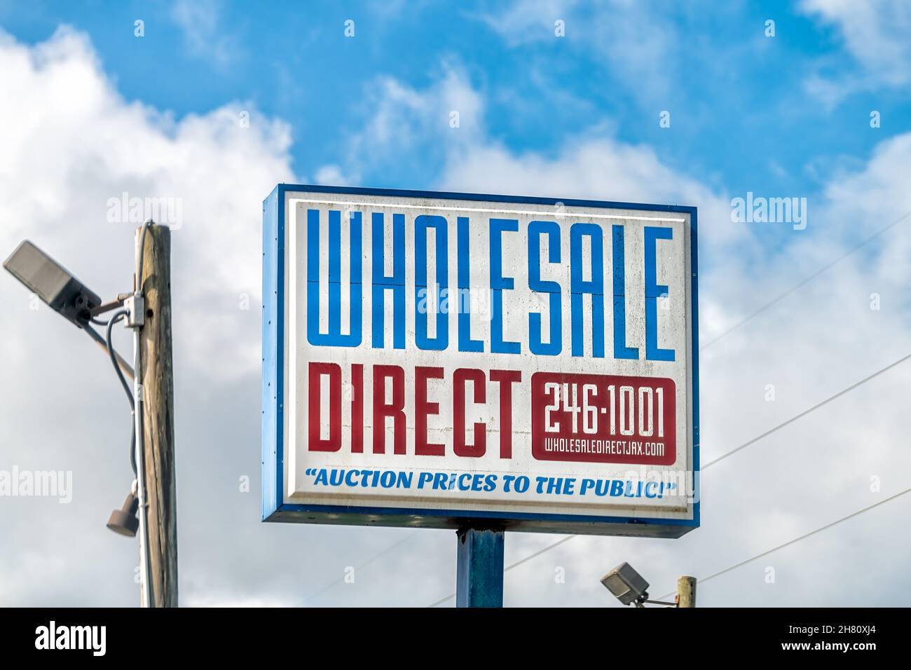 Jacksonville, USA - July 8, 2021: Sign advertisement billboard on street road for Wholesale direct auction prices to public of used cars vehicles with Stock Photo