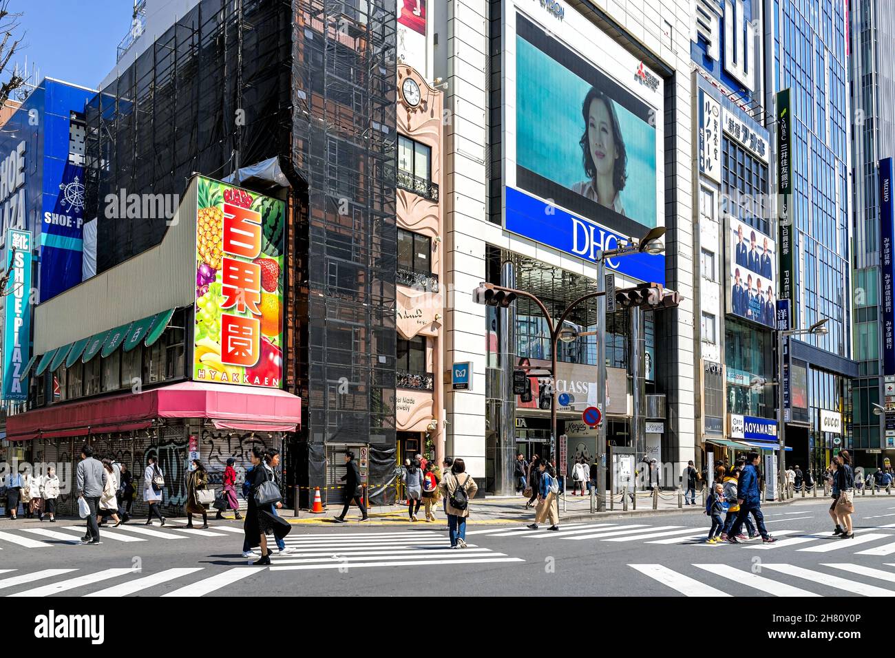 Tokyo, Japan - April 2, 2019: Shinjuku crosswalk with business many people candid on commute crossing street in morning rush hour on road with signs f Stock Photo