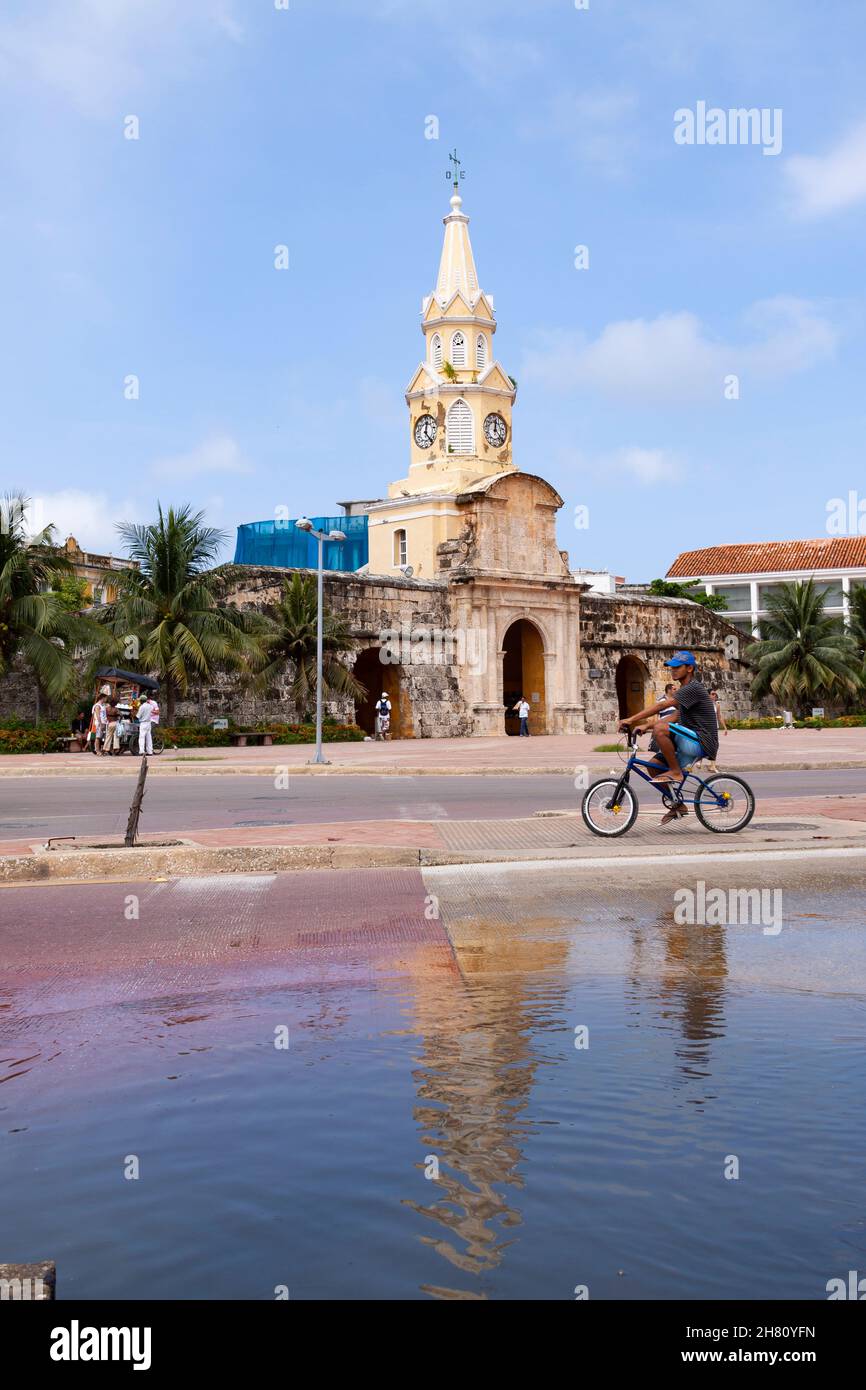 Cartagena de Indias, Colombia - Nov 21, 2010: The Clock Tower Monument, in the historic center of the city, behind a huge pool of water and a kid on a Stock Photo