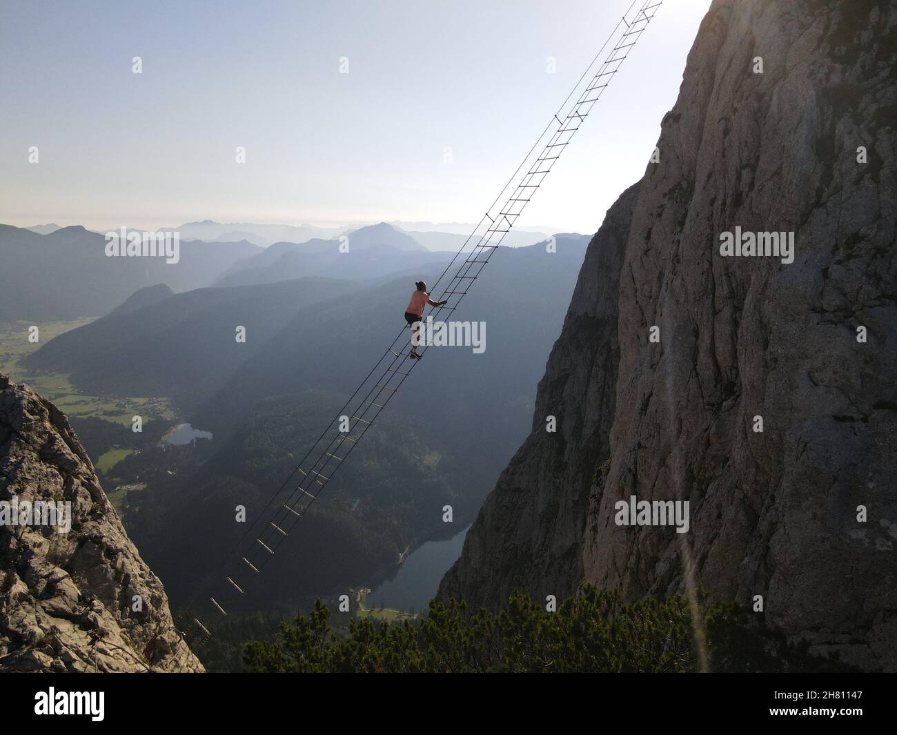 One of the most famous via ferratas in the world. The Intersport via ferrata on Donnerkogel in Austria. A man climbs to the other side of the mountain Stock Photo