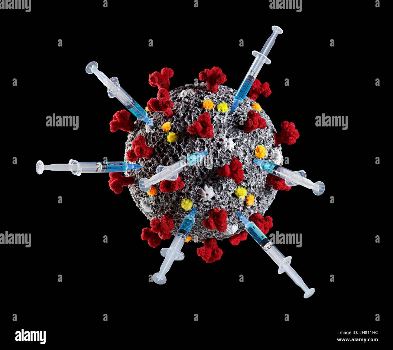 the coronavirus molecule, with vaccine syringes Stock Photo