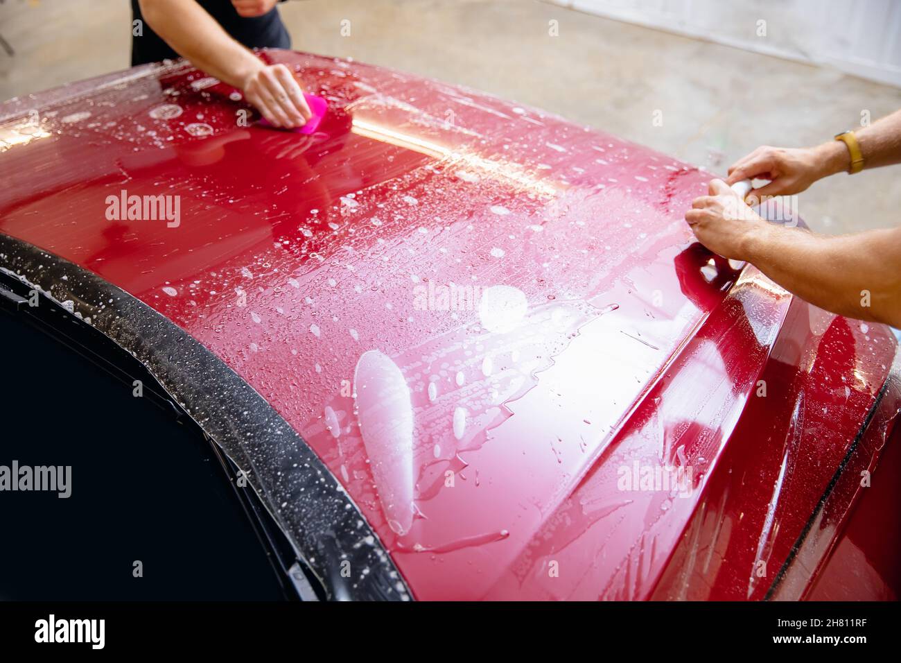 Protección de pintura de primer plano PPF es una película de vinilo,  instalación maestra en el capó moderno coche de lujo Fotografía de stock -  Alamy