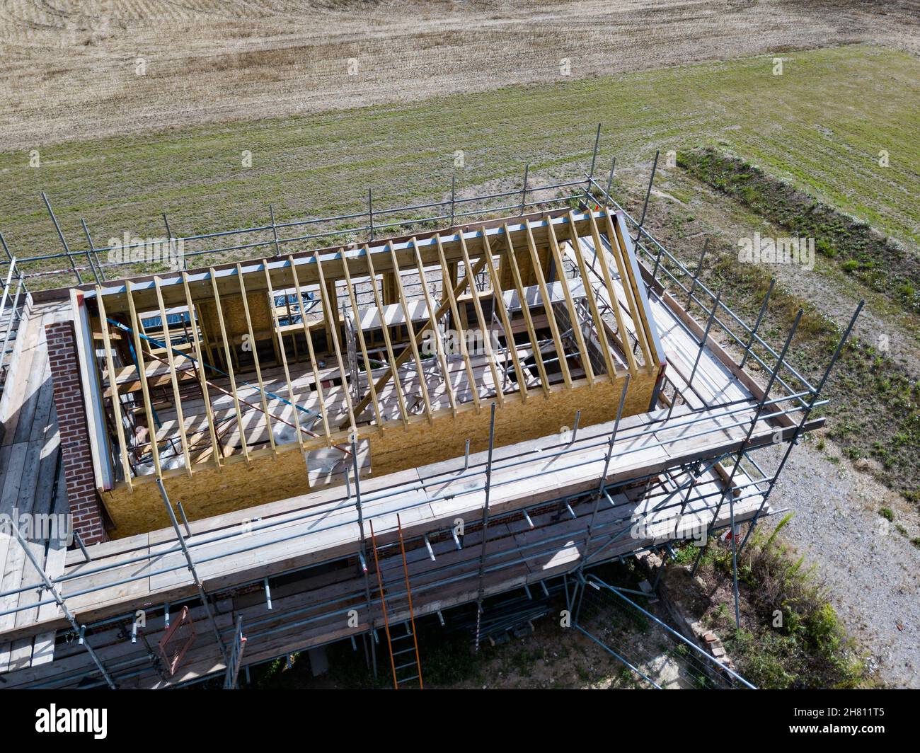 Aerial view of an unfinished barn conversion with scaffolding surrounding the structure Stock Photo