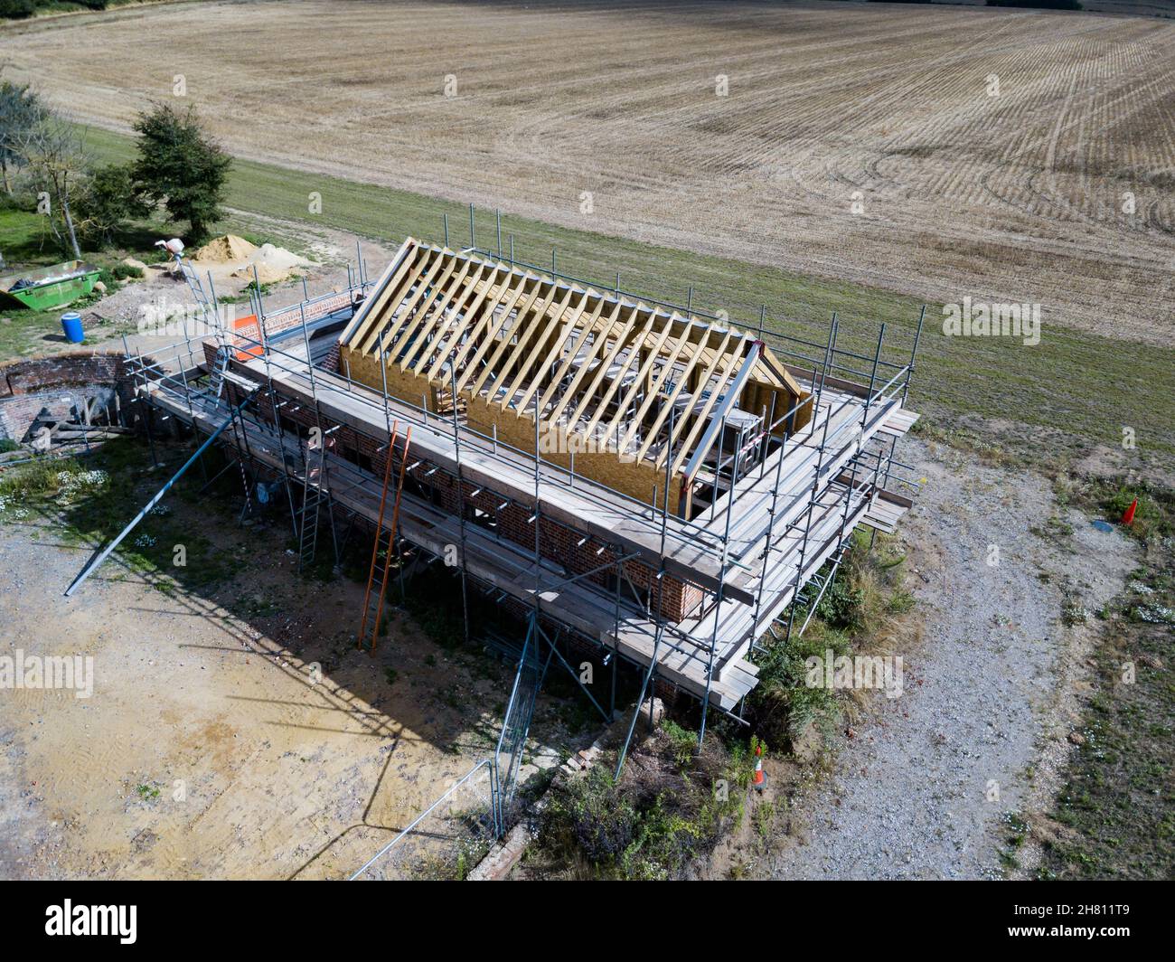 Aerial view of an unfinished barn conversion with scaffolding surrounding the structure Stock Photo