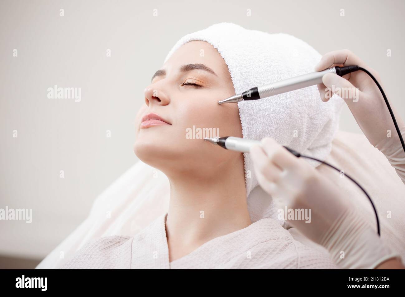 Young woman having micro current galvanic facial treatment with