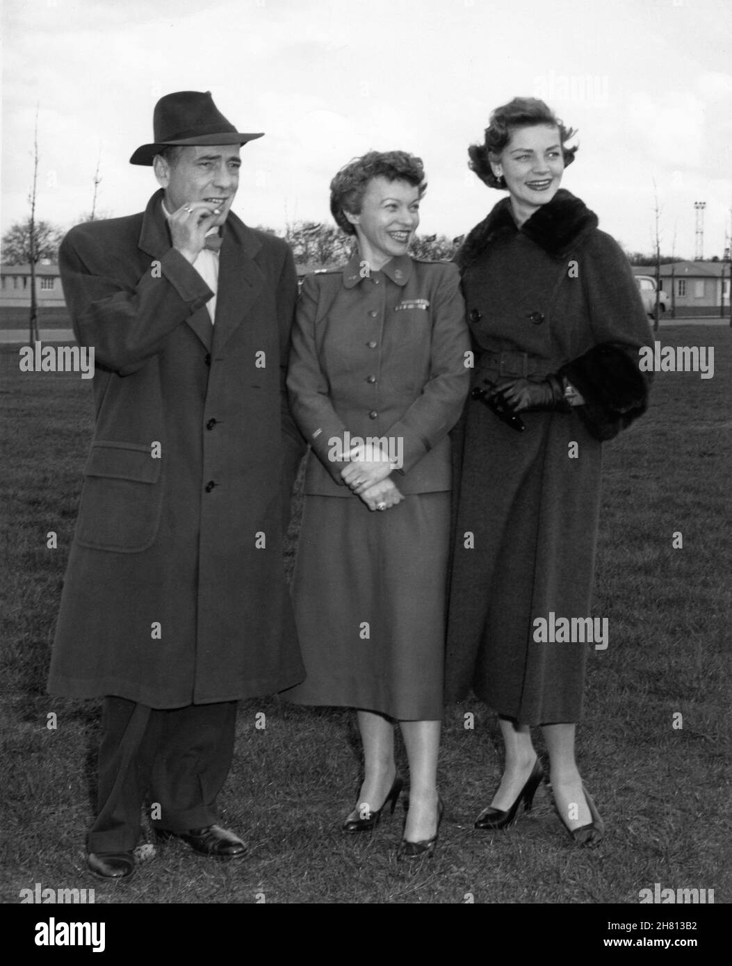 HUMPHREY BOGART and his wife LAUREN BACALL with commanding officer Captain ROBERTA McWILLIAMS U.S. Army when meeting the International Women's Detachment during a visit to SHAPE (Supreme Headquarters Allied Powers Europe) in Rocquencourt near Versailles in France on 30th March 1954 Stock Photo