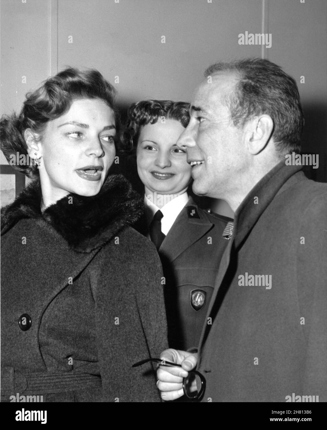 HUMPHREY BOGART and his wife LAUREN BACALL with MIMOSA NIKOLITCH of the French Army when meeting the International Women's Detachment during a visit to SHAPE (Supreme Headquarters Allied Powers Europe) in Rocquencourt near Versailles in France on 30th March 1954 Stock Photo