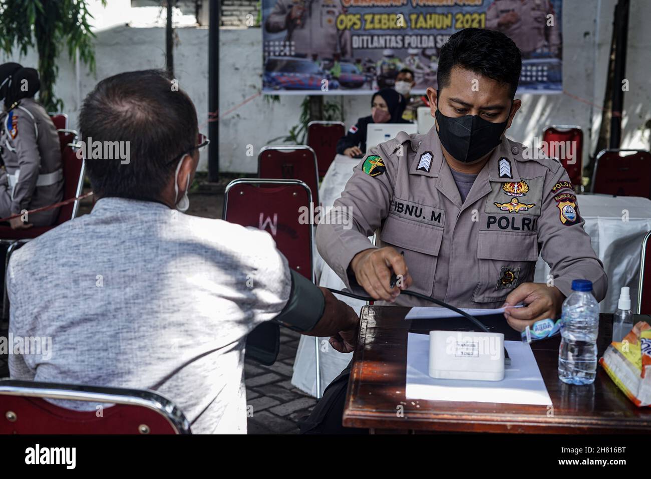 Makassar, South Sulawesi, Indonesia. 26th Nov, 2021. A health worker is checking the body condition of a candidate for the Covid-19 vaccination at the Makassar Samsat Office. (Credit Image: © Herwin Bahar/ZUMA Press Wire) Credit: ZUMA Press, Inc./Alamy Live News Stock Photo