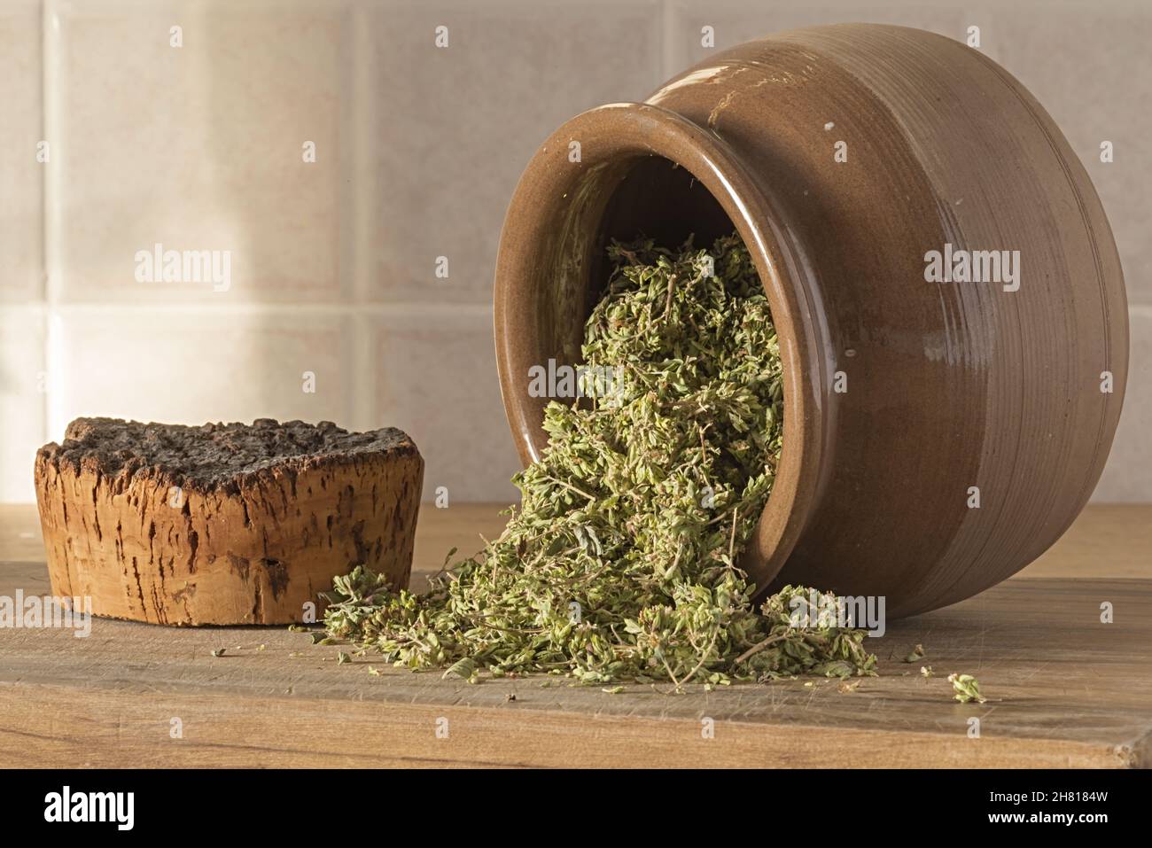 origano secco in vaso di coccio marrone rovesciato Stock Photo