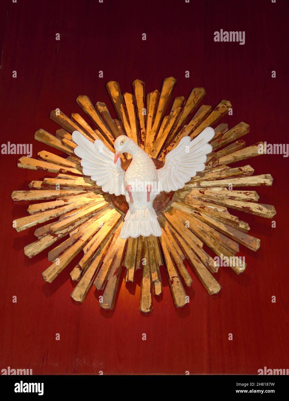Holy Spirit in golden wood on a red wall. Stock Photo