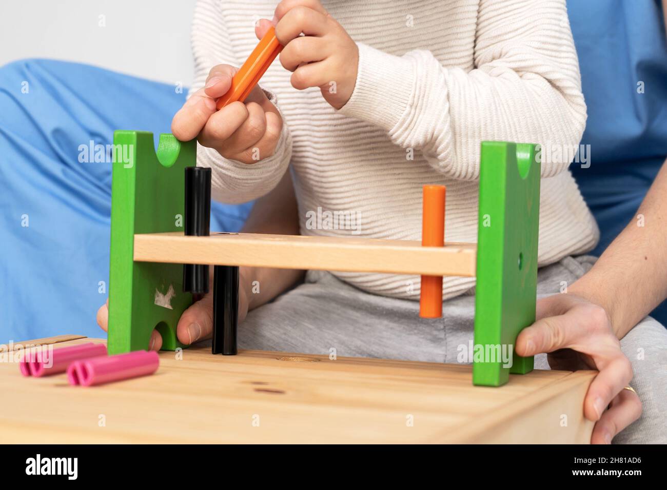 Close up view of a Therapist doing development activities with a little boy. Boy with cerebral palsy having rehabilitation, learning. Training in medical care center. High quality photo. Stock Photo