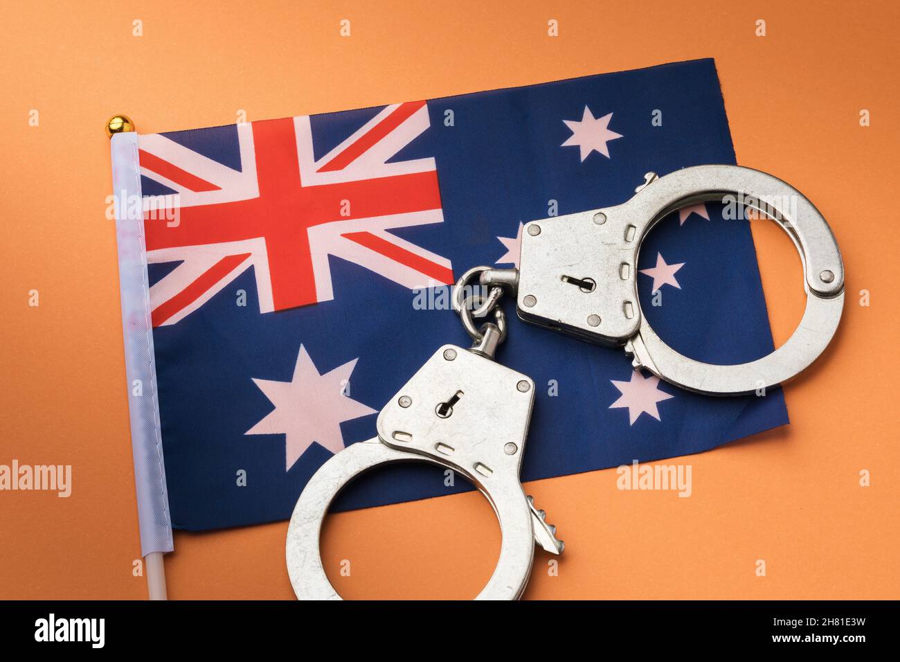 Australia flag and handcuffs on orange background, concept on the theme of crime in the country
