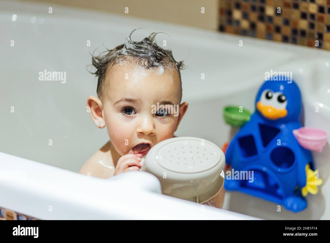 Little girl enjoying taking a bath in bathtub at home Stock Photo Alamy