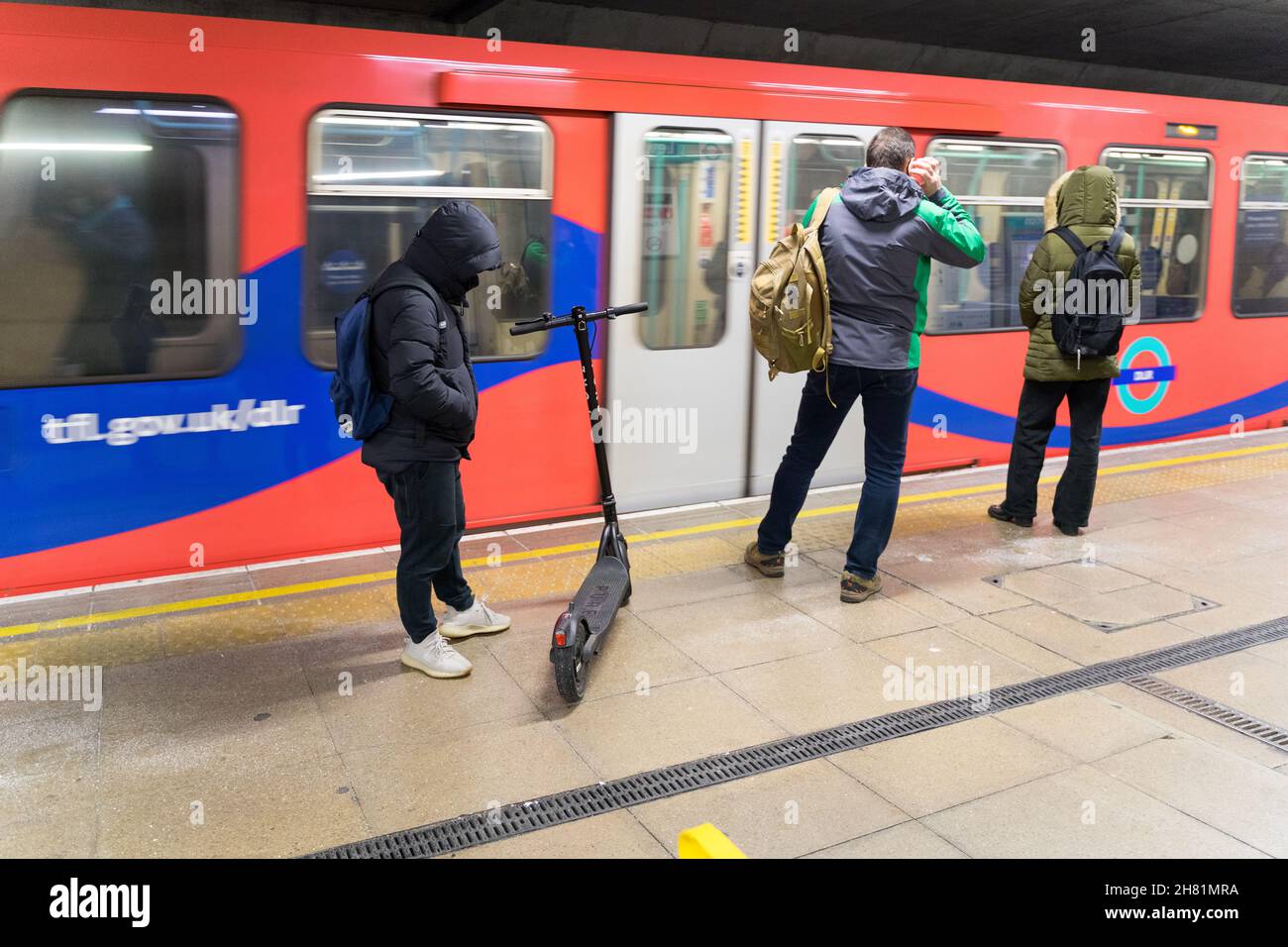London, UK. 26th November 2021. Commuters about to board DLR train to work, when RMT go ahead with  24 hours strike action on five London underground lines, in a dispute over new shift patterns as the Night Tube service is due to resume this weekend. Credit: Xiu Bao/Alamy Live News Stock Photo