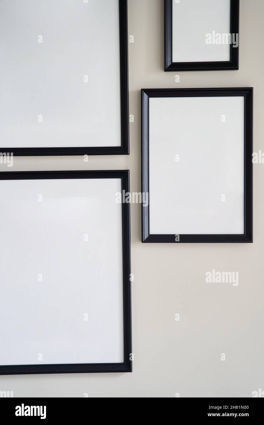 Different size framed photos hanging on the gray wall. Mockup. Stock Photo