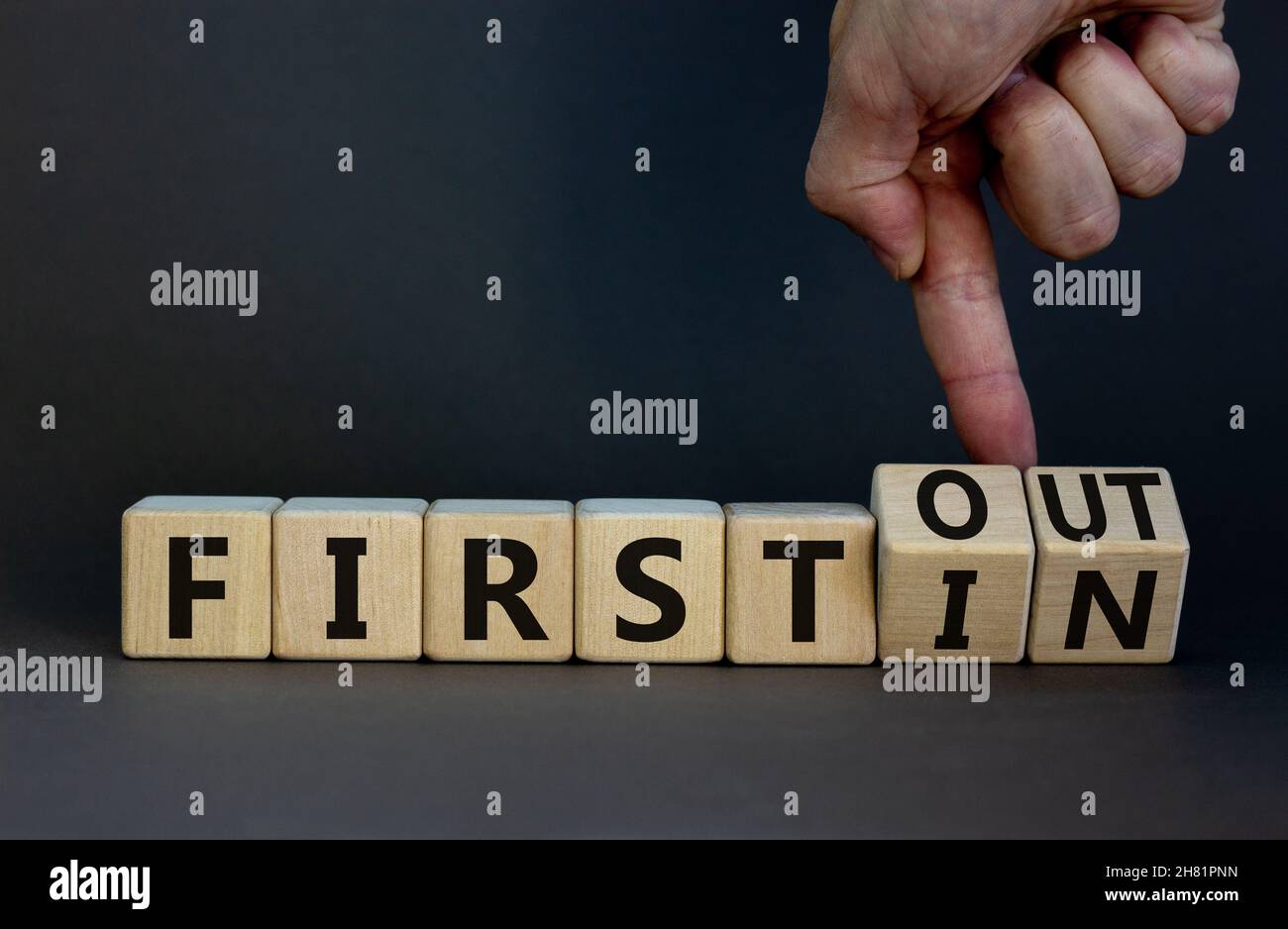 First in first out symbol. Businessman turns wooden cubes and changes ...