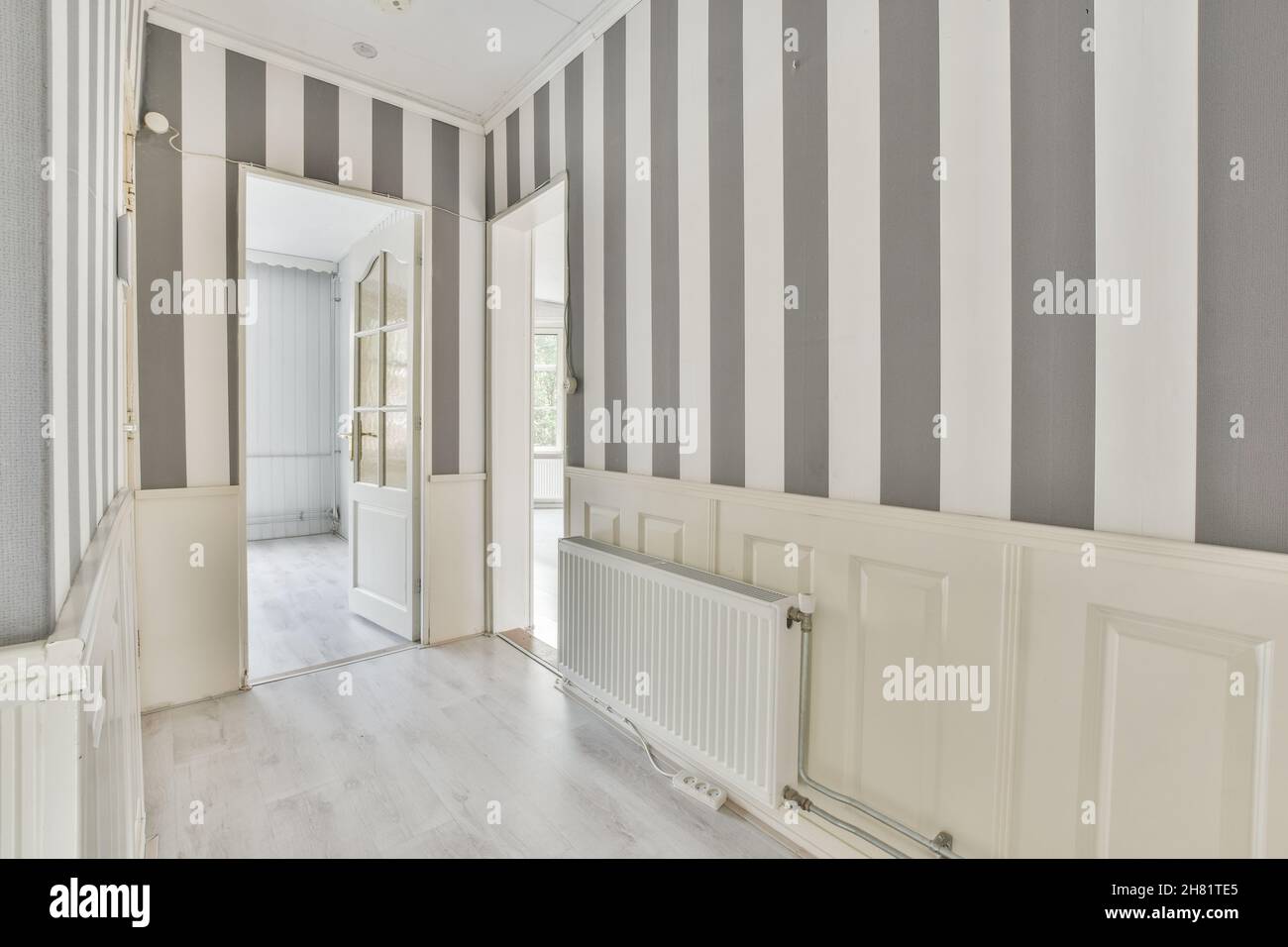 Corridor of a modern apartment with black white striped wallpaper Stock Photo