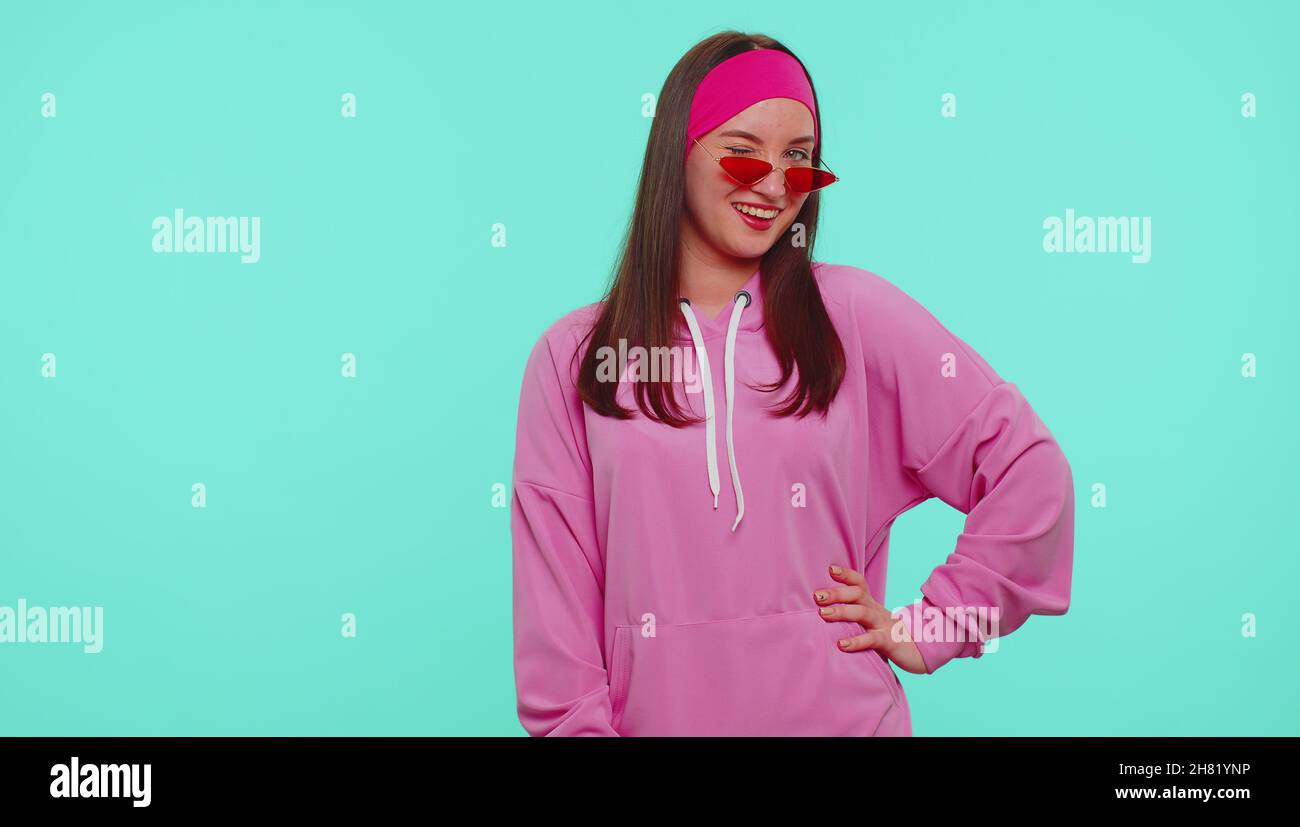 Seductive cheerful positive teen girl in hoodie wearing sunglasses