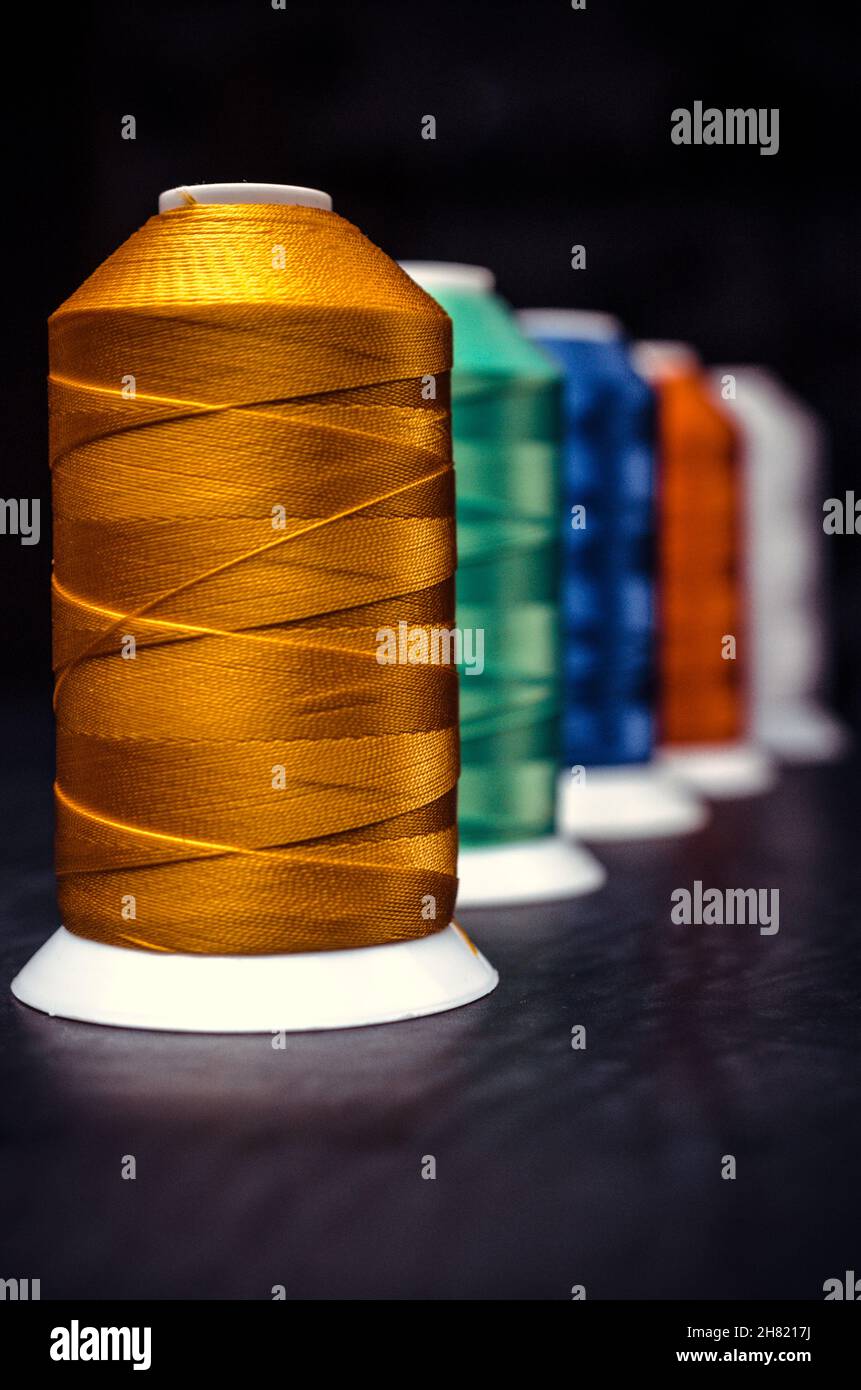 Several of multi-colored spools of threads. Perspective on a black background Stock Photo