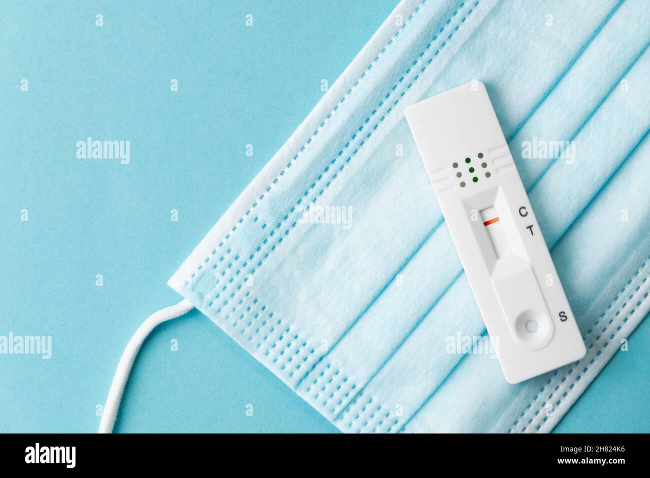 Negative rapid SARSCOV2 antigen test card over a surgical mask on a