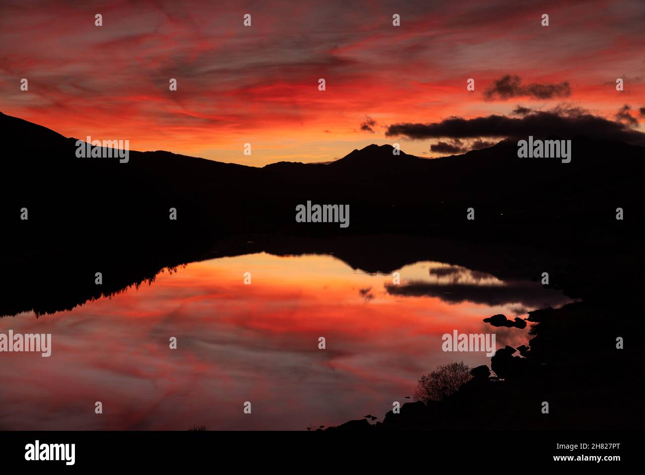 Reflection of colourful sky at dusk in Llyn Mymbyr, Snowdonia, North Wales Stock Photo