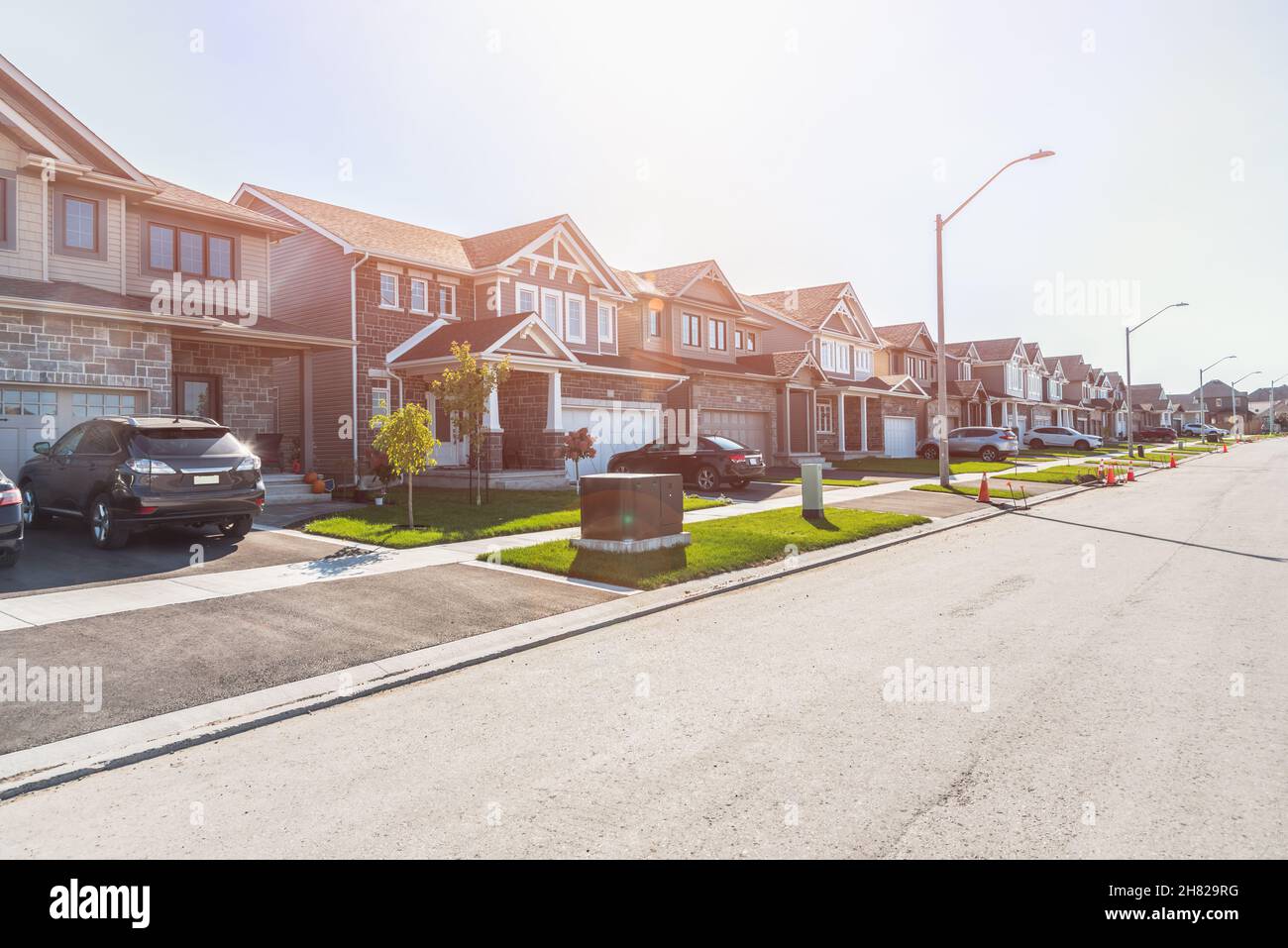 Row of newly built houses ina housing development on a sunny autumn day. Lens flare. Stock Photo