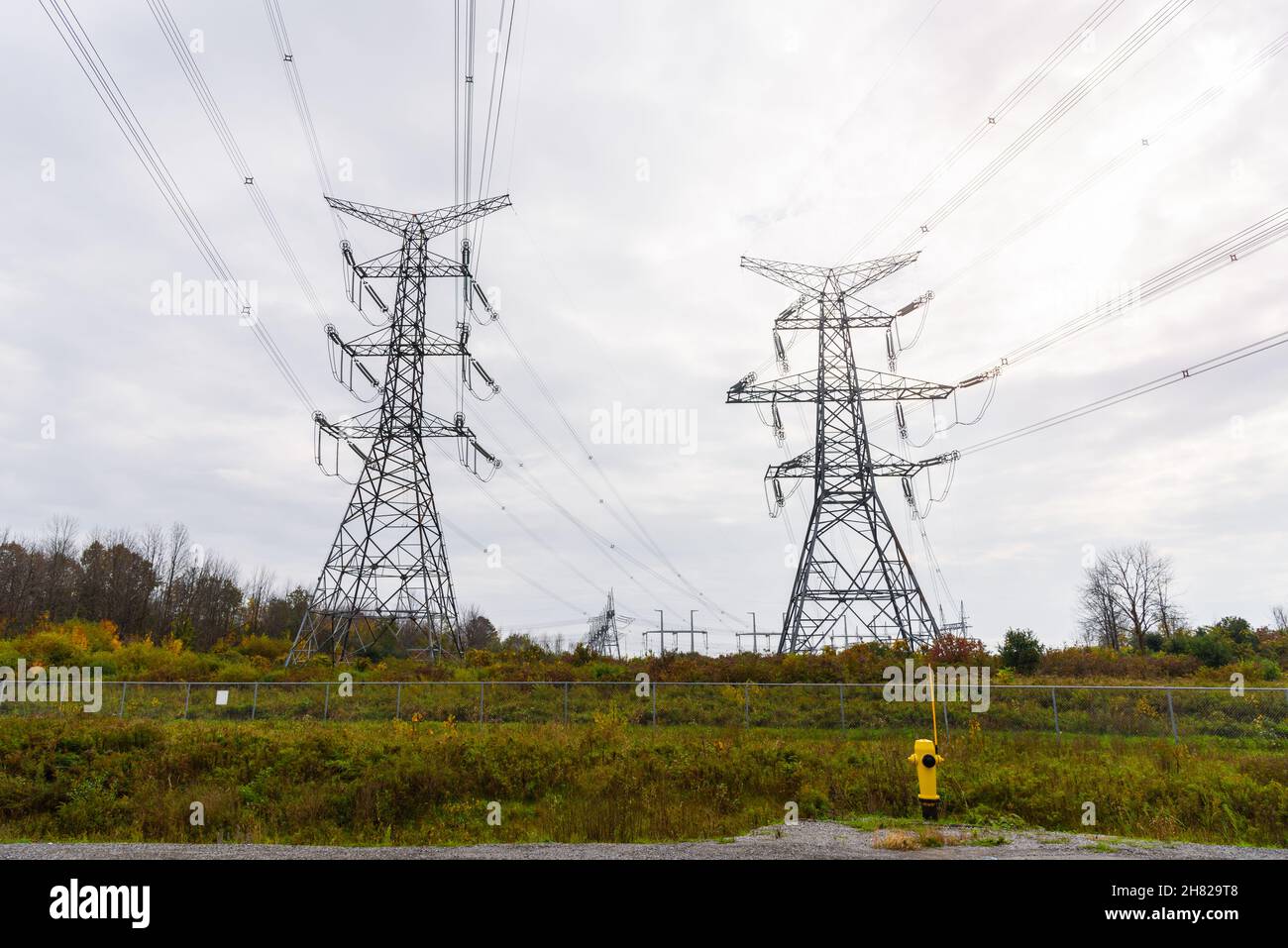 Tall high voltage electricity pylons in the countryside on a overcast autumn day Stock Photo