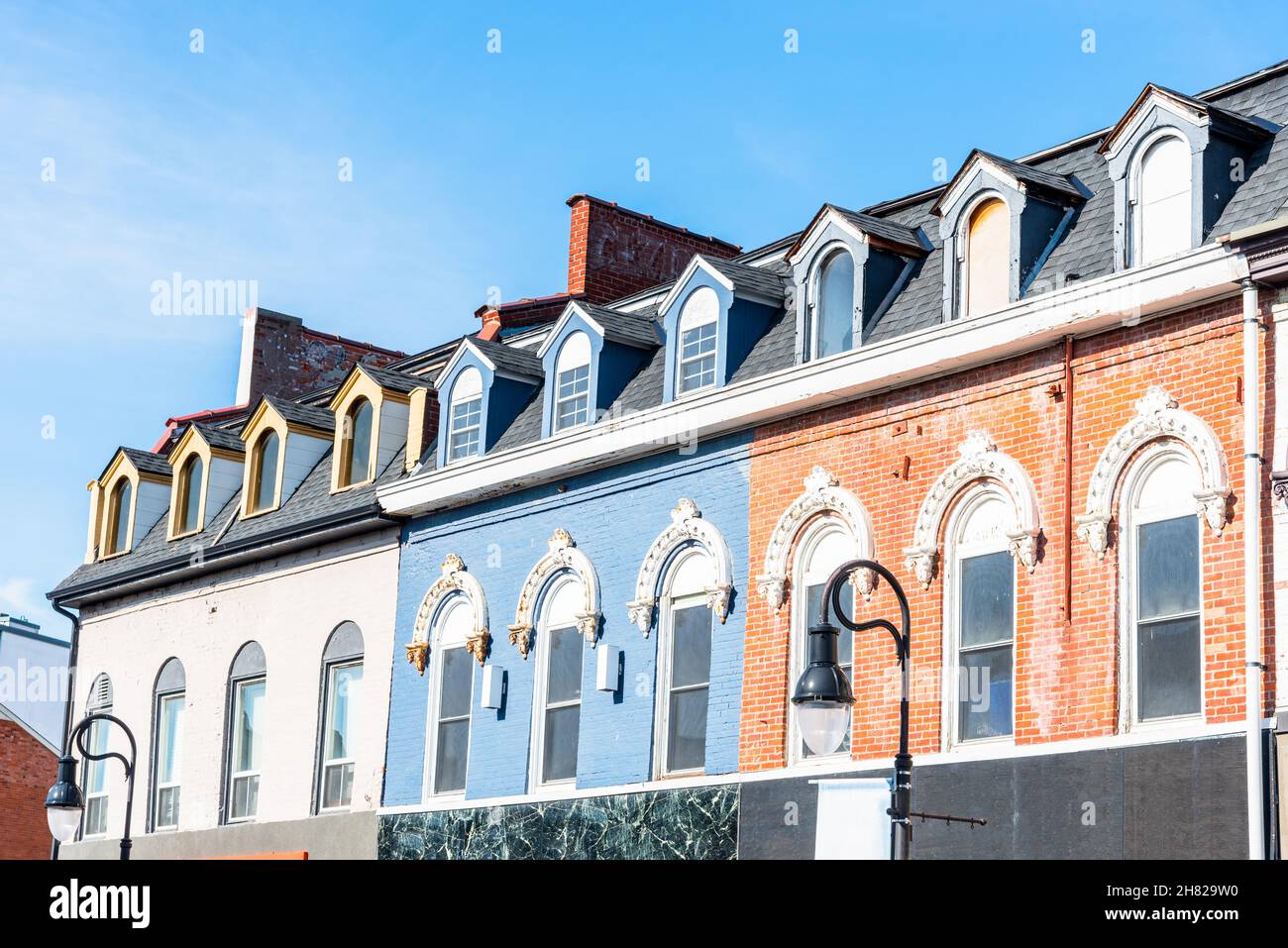 Row of historic buildings with shops on ground level in a city centre on a sunny autumn day Stock Photo