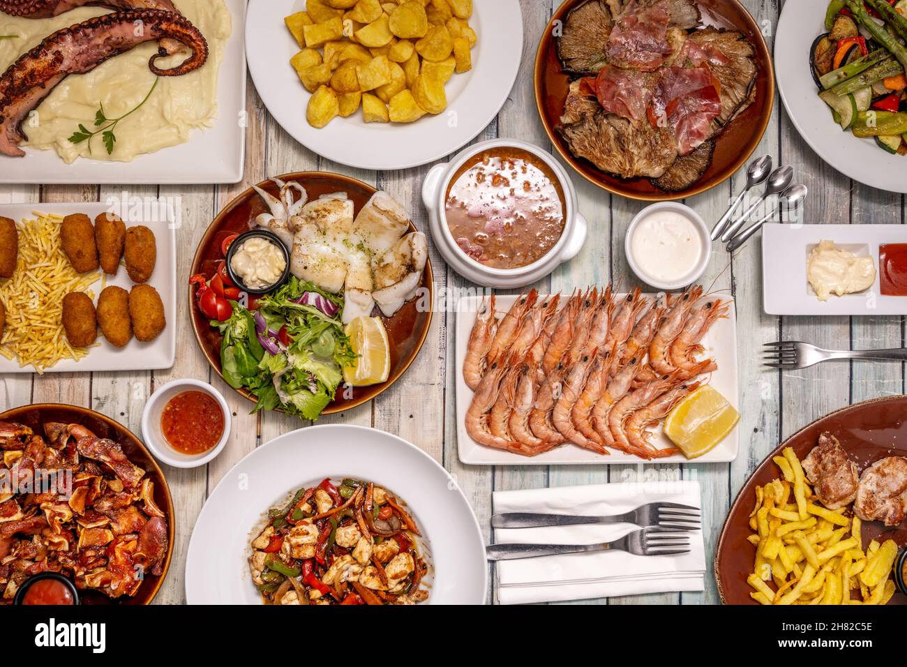 Set of great dishes of Spanish food and tapas, grilled prawns, octopus with potatoes, spicy bravas, grilled cuttlefish, ear, serrano ham croquettes, m Stock Photo