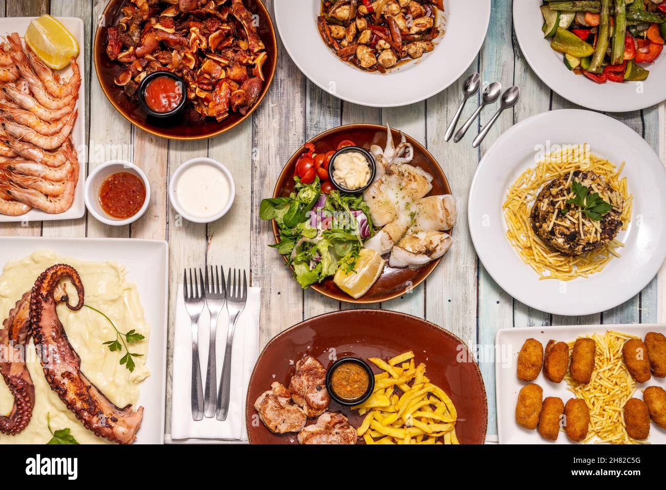 Set of great dishes of Spanish food and tapas, grilled prawns, octopus with potatoes, spicy bravas, grilled cuttlefish, ear, serrano ham croquettes, m Stock Photo