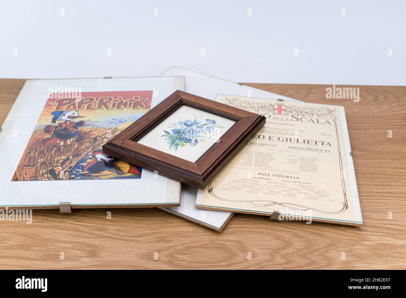 glass clip frames with posters on a wooden tabletop background Stock