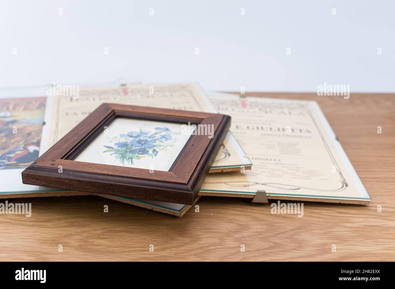 glass clip frames with posters on a wooden tabletop background Stock