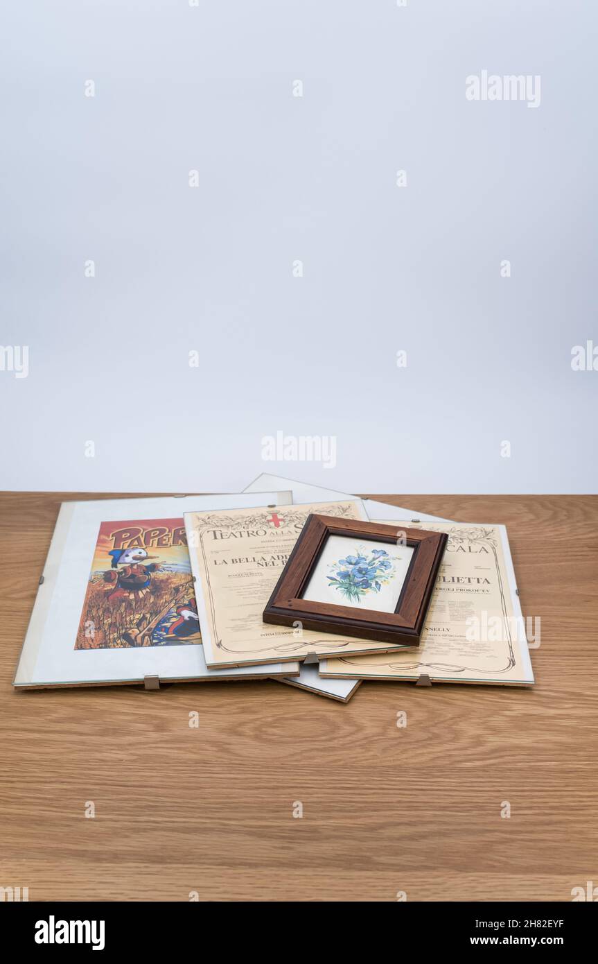 glass clip frames with posters on a wooden tabletop background Stock