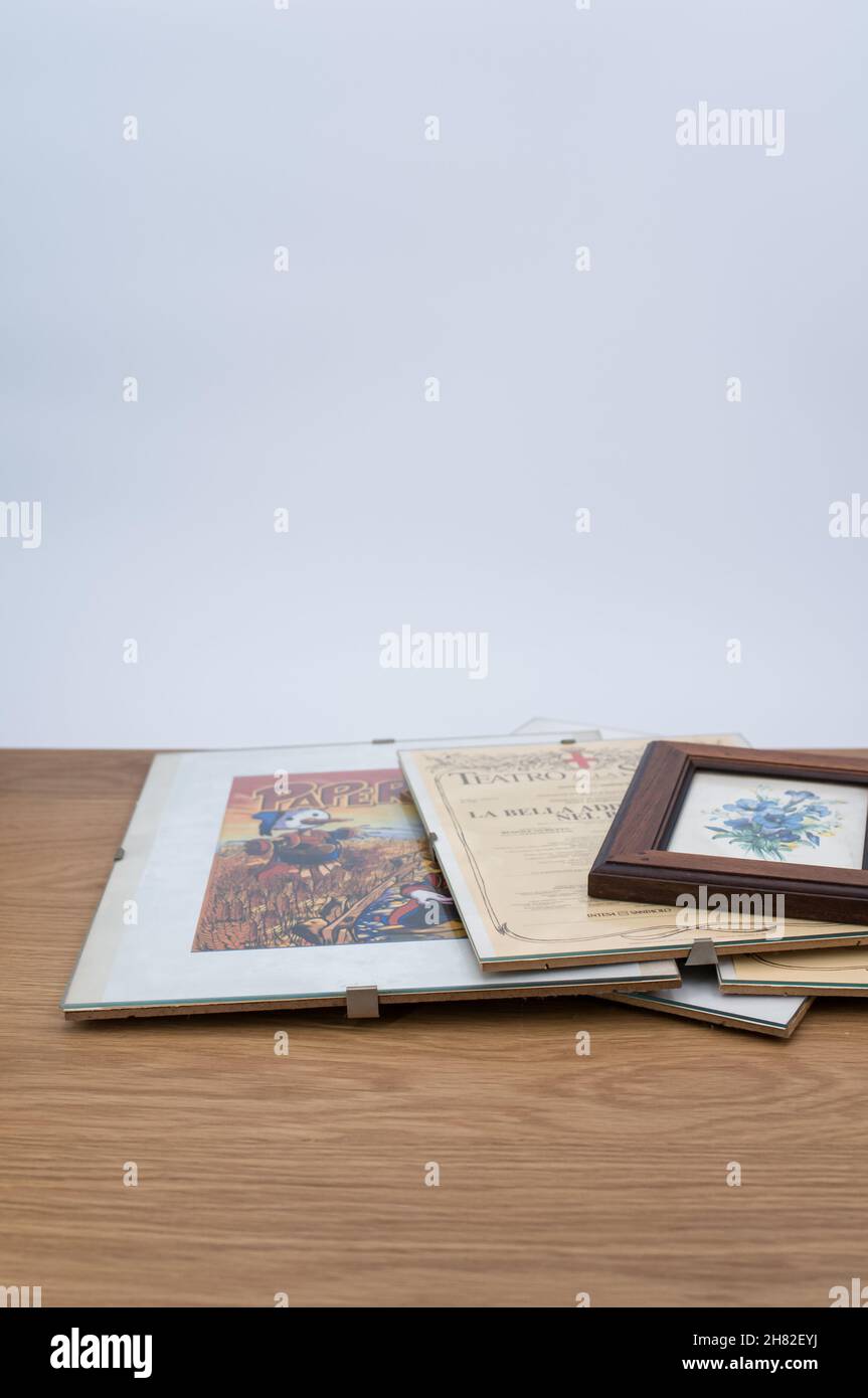 glass clip frames with posters on a wooden tabletop background Stock