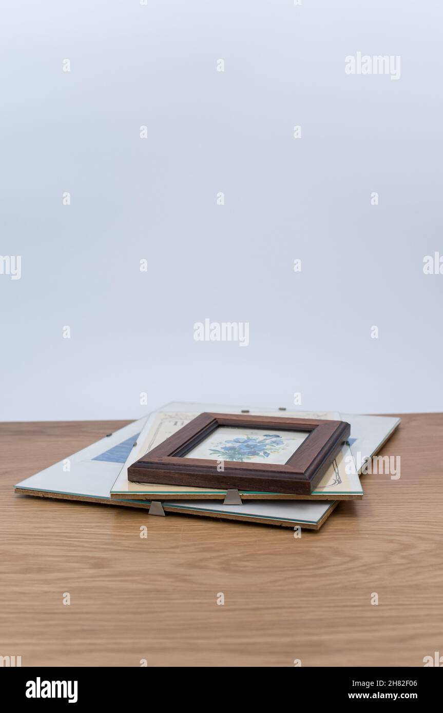 glass clip frames with posters on a wooden tabletop background Stock