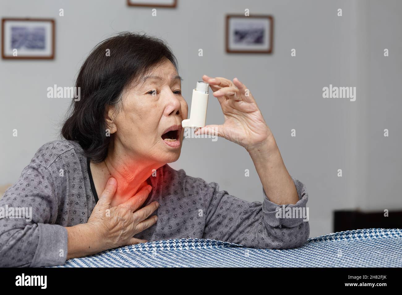 Elderly woman choking and holding an asthma spray Stock Photo - Alamy