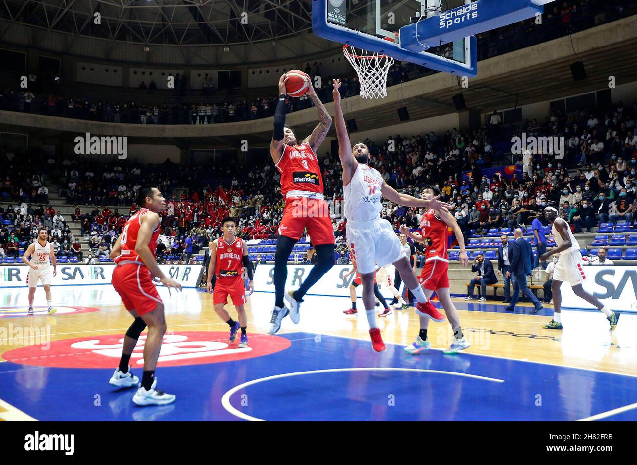 Beirut, Lebanon. 26th Nov, 2021. Brandon van Dorn Jawato (L, front) of  Indonesia goes for a lay-up during the Asian qualifiers of the FIBA  Basketball World Cup 2023 between Lebanon and Indonesia