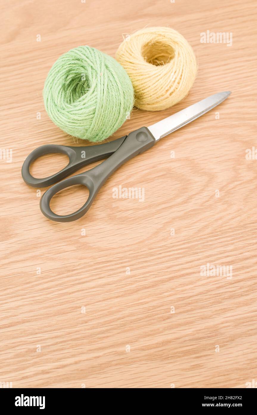 decorative rustic green yellow yarn ball and scissors on a wooden ...