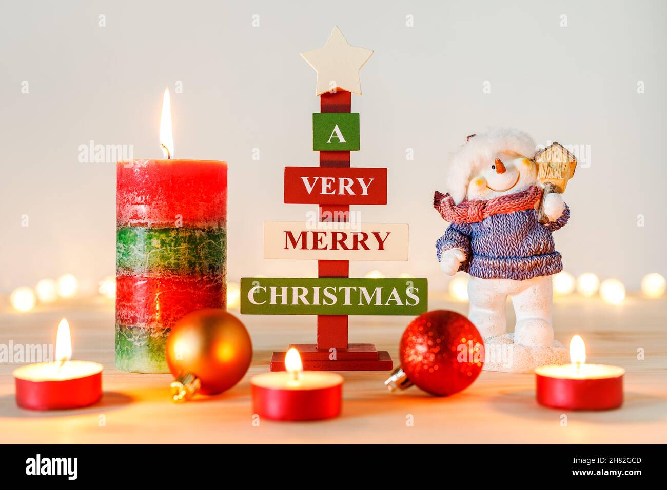 Christmas decorations on wooden table with defocused holiday lights in background Stock Photo