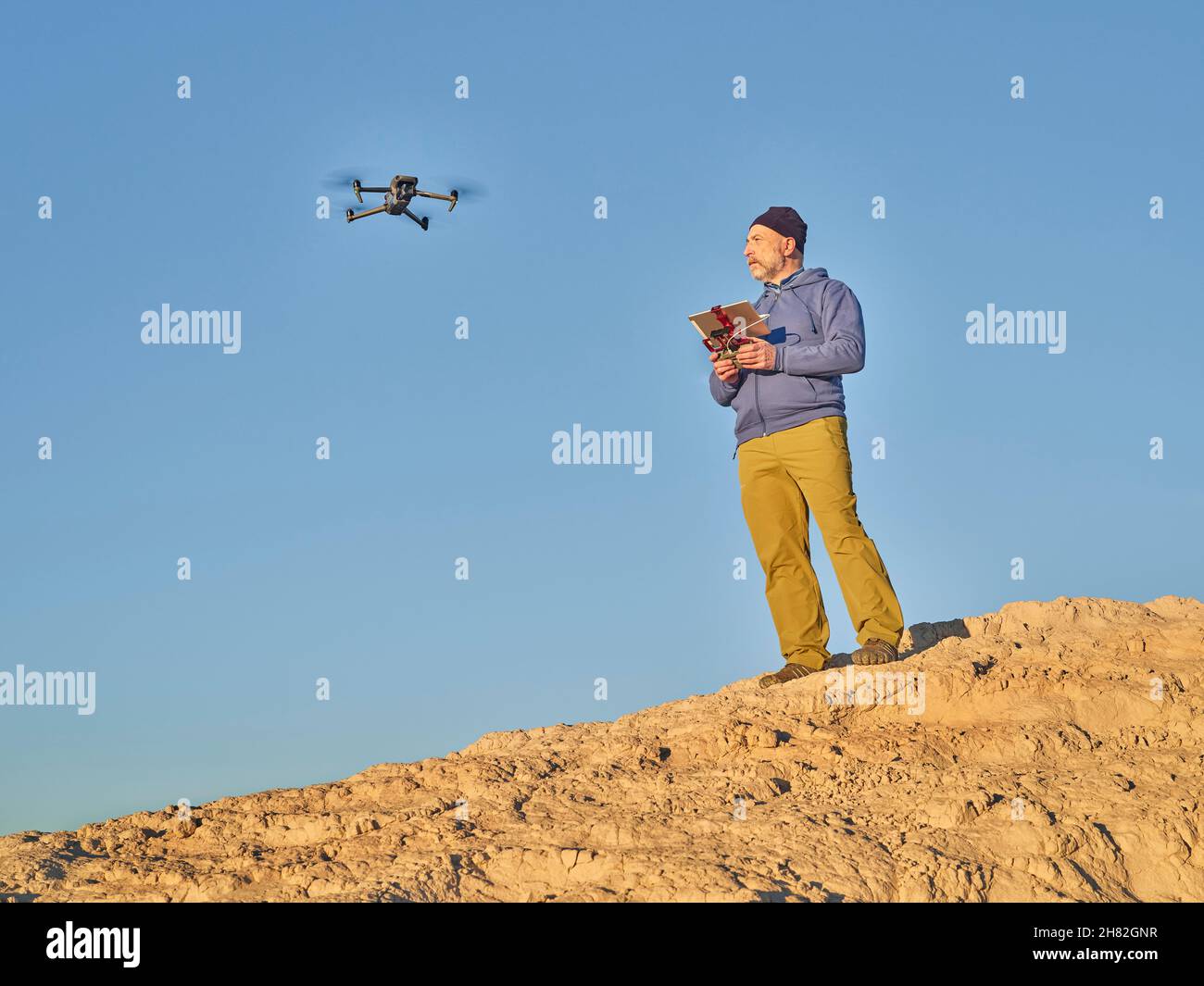 Grover, CO, USA - November 22, 2021: Senior male pilot with ipad tablet and radio controller is operating Mavic 3, an advanced, foldable consumer dron Stock Photo