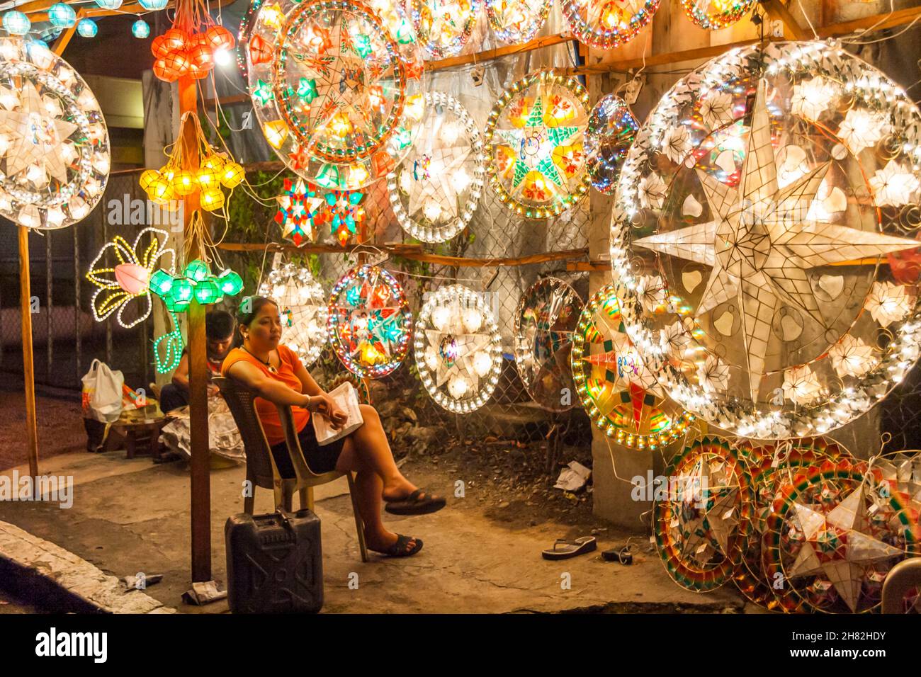 Vendor at a roadside christmas lantern shop waiting for customers in