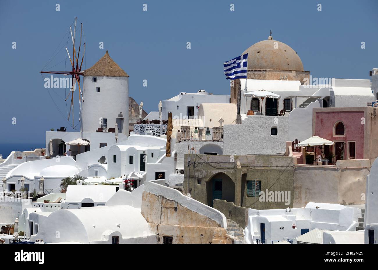 Oia Town and windmill at beautiful Greek island Santorini in Greece. Oia is a small town and former community in the South Aegean on the Santorini. Stock Photo