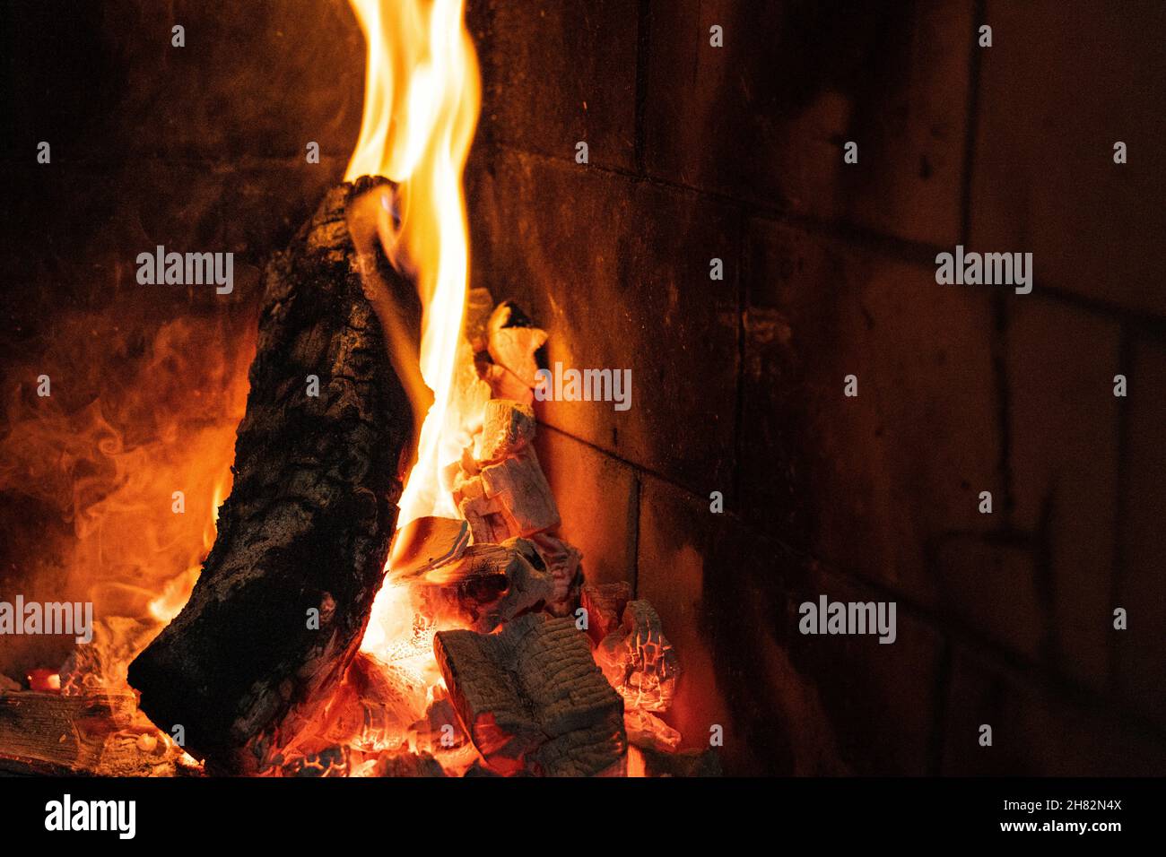 Wallpaper of a fire on a brick background. Stock Photo