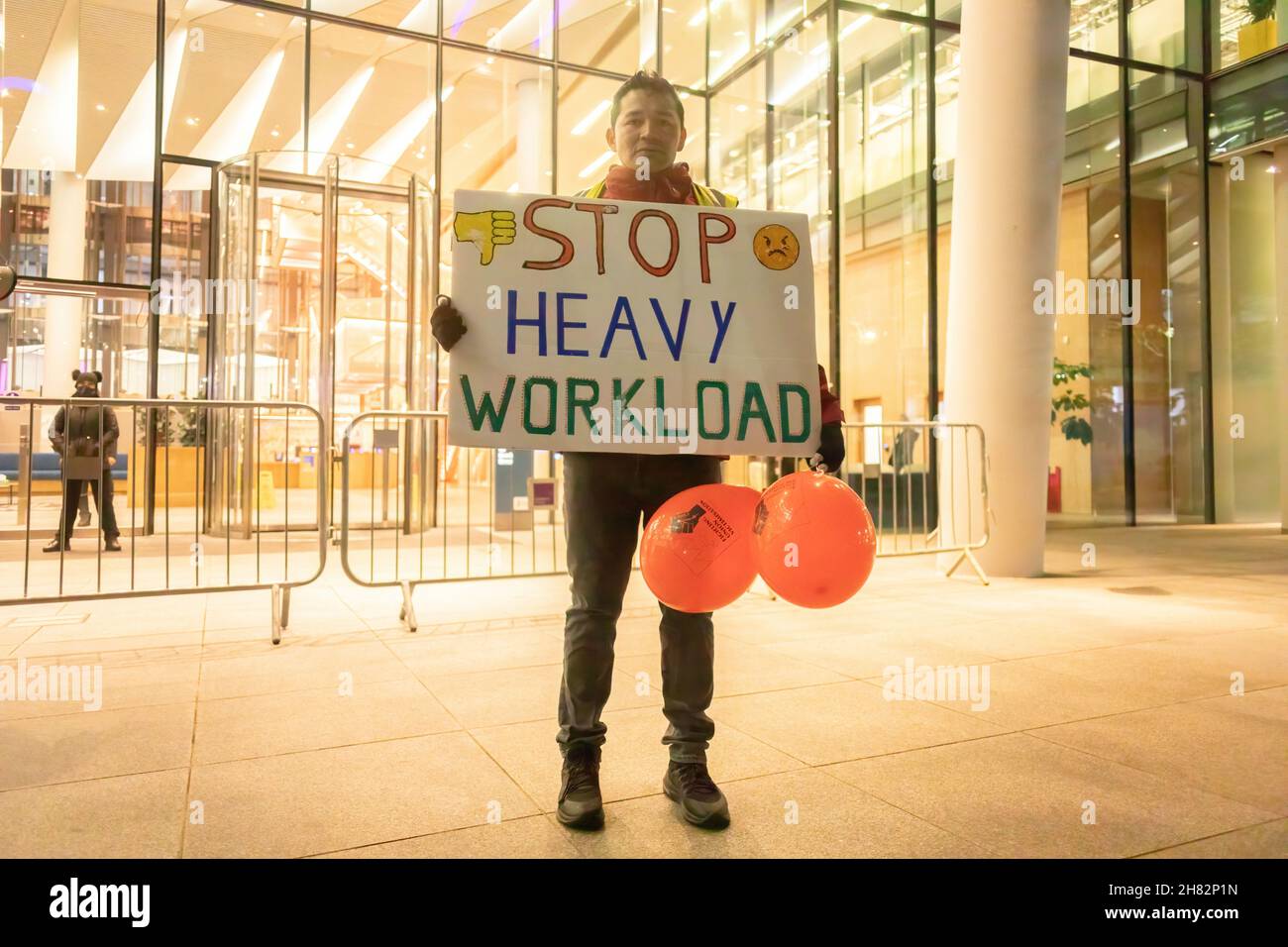 London, UK. 26th Nov, 2021. A protestor is seen holding a placard that says 'Stop heavy workload' during a protest outside the Facebook headquarters at Warren Street in London.The group of protesters led by the Independent Workers Union protested at the Facebook London office after it increased workload without a salary increase. Jones Lang LaSalle (JLL) has outsourced the cleaning obligations to Churchill Services to clean the office of Facebook. Also, they allegedly mistreated the cleaners which resulted to the protest. Credit: SOPA Images Limited/Alamy Live News Stock Photo