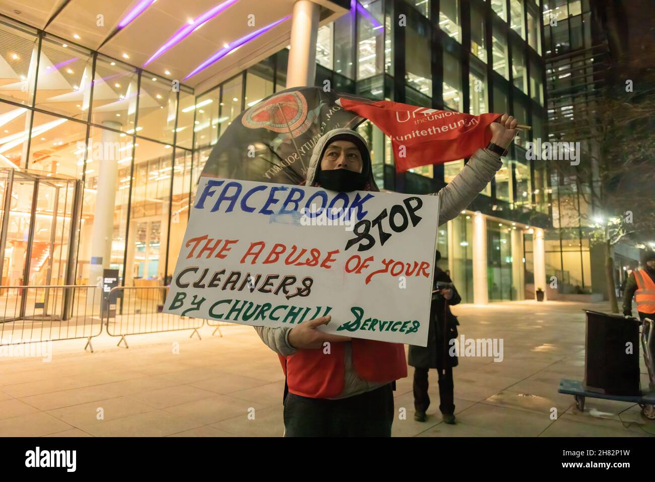 A protestor is seen holding a placard that says 'Facebook, stop the abuse of your cleaners by Churchill services' during a protest outside Facebook headquarters at Warren Street in London.The group of protesters led by the Independent Workers Union protested at the Facebook London office after it increased workload without a salary increase. Jones Lang LaSalle (JLL) has outsourced the cleaning obligations to Churchill Services to clean the office of Facebook. Also, they allegedly mistreated the cleaners which resulted in the protest. Stock Photo