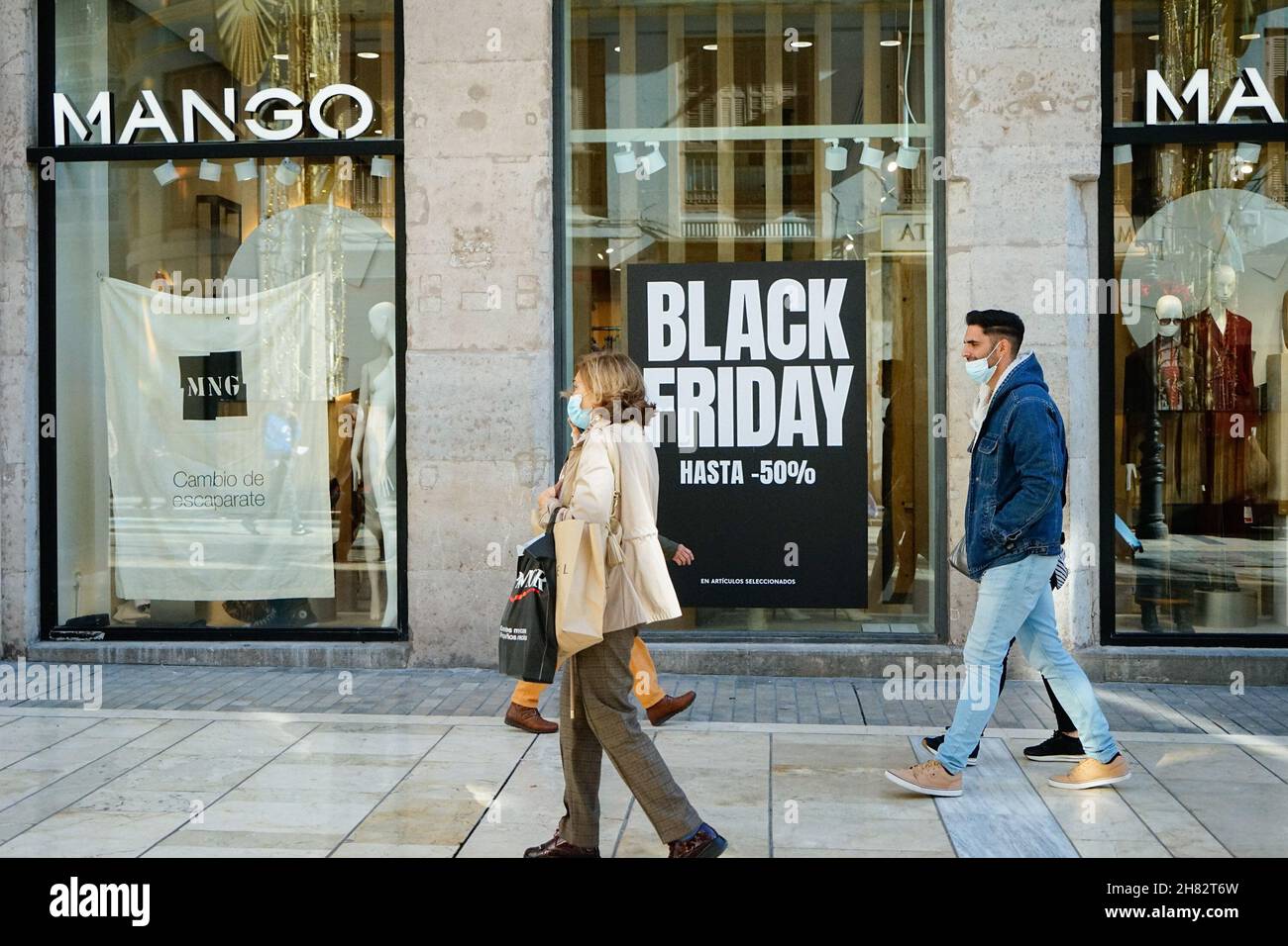 Malaga, Spain. 26th Nov, 2021. People walk past a Mango store that offers a  50% discount on a Black Friday in Malaga.In 2021, online commerce has grown  by 71% after consumers fear