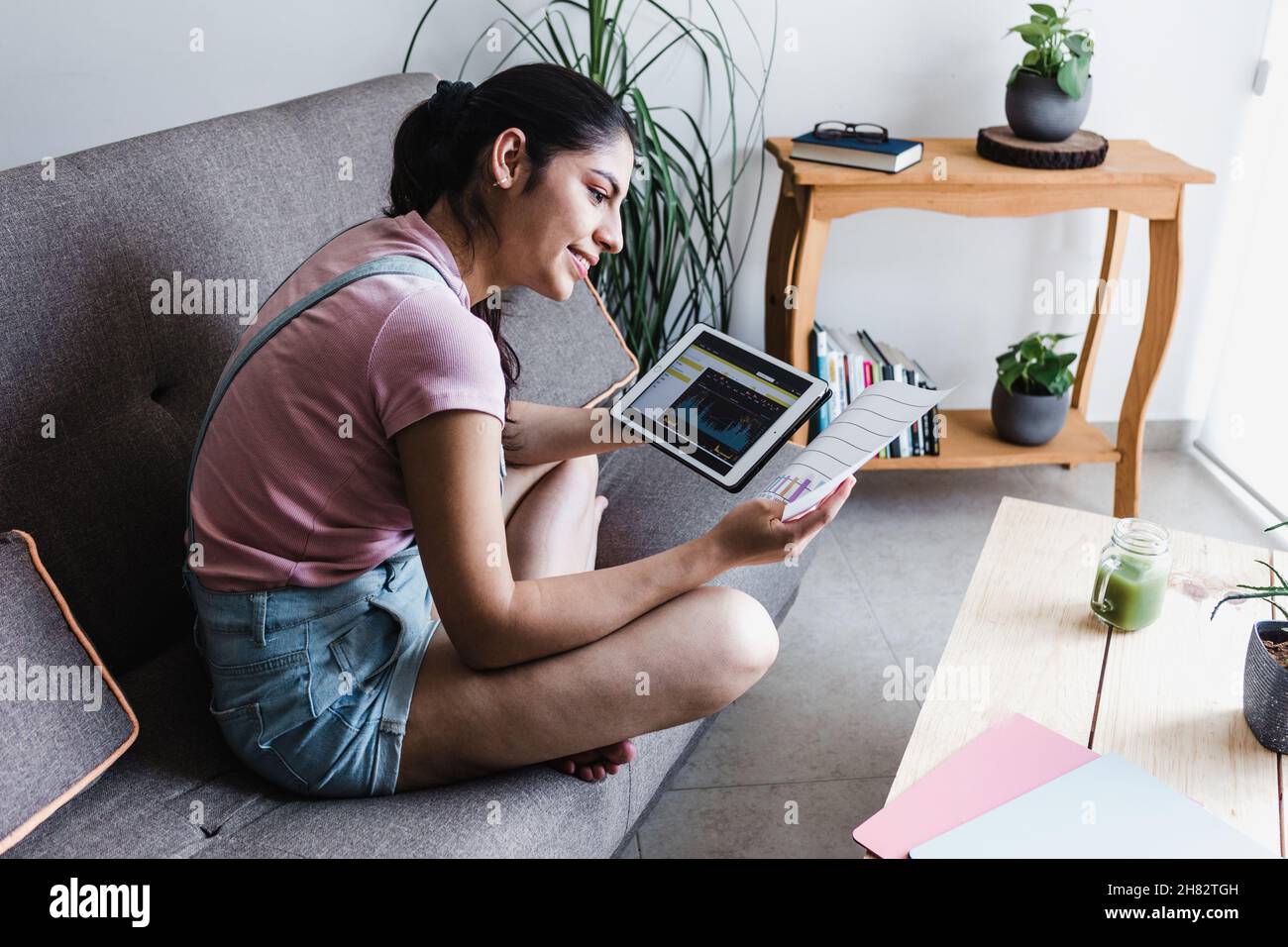 young latin Woman Trading With Cryptocurrency and reviewing statistics in  digital tablet at home in Mexico Latin America Stock Photo - Alamy