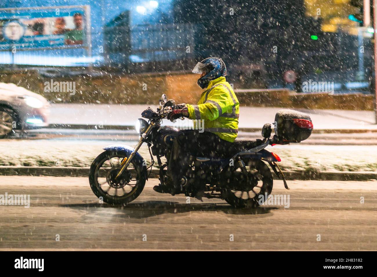 Cradley Heath, West Midlands, UK. 27th Nov, 2021. A motorcyclist negotiates a steep hill as a blanket of snow hits the the roads in Cradley Heath, West Midlands, as Saturday morning traffic is thanksfully light. Road conditions are dangerous. Credit: Peter Lopeman/Alamy Live News Stock Photo