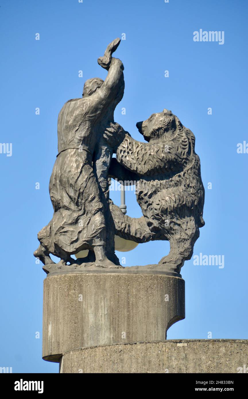 Skulptur auf der Gallusbrücke vor den Toren von Wangen im Allgäu zeigt den Kampf von Hl.Gallus mit dem Bären gegen den blauen Himmel, Stock Photo