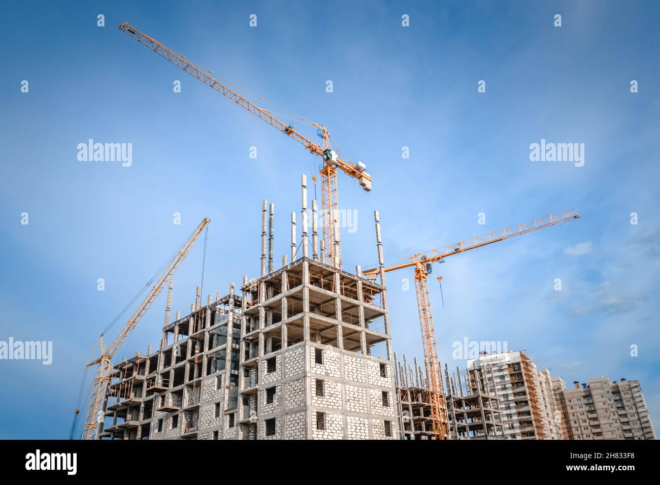 Construction of highrise building and hoisting tower cranes Stock Photo